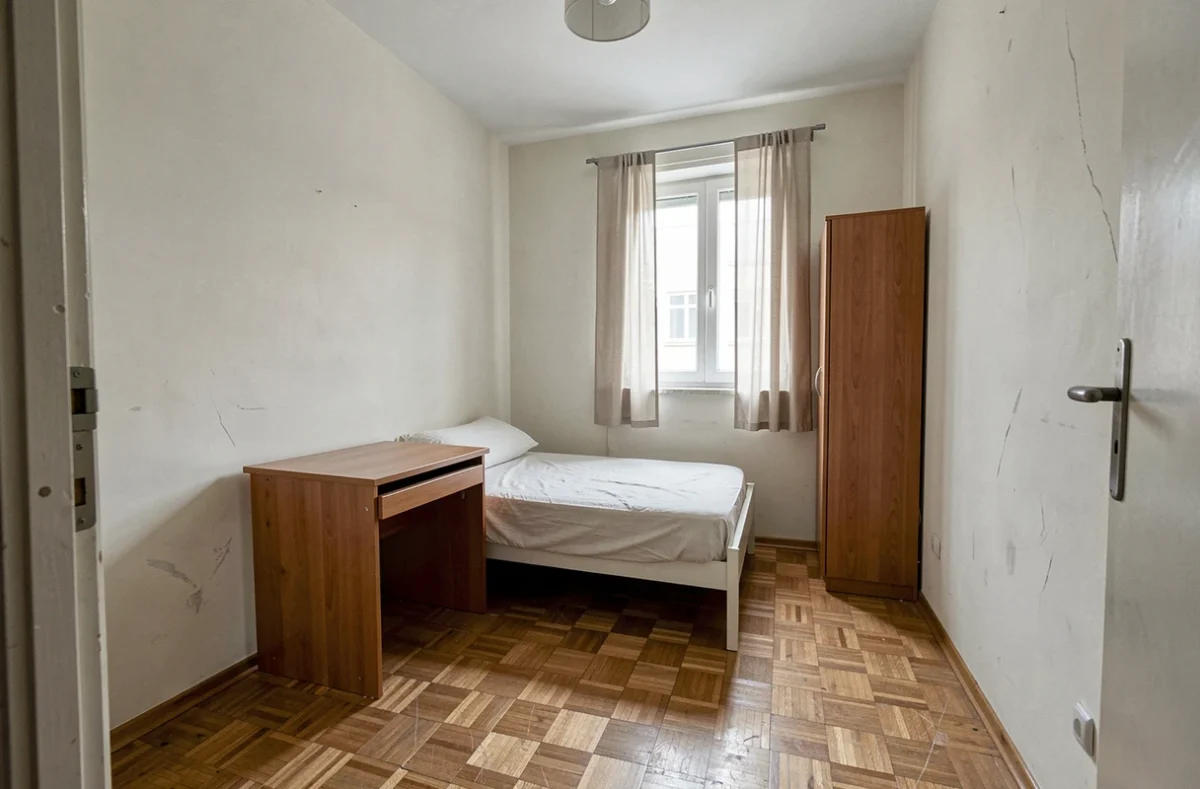 Petite chambre de moins de 9m2 avec lit simple et bureau dans un appartement à vendre