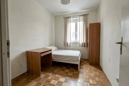 Petite chambre de moins de 9m2 avec lit simple et bureau dans un appartement à vendre